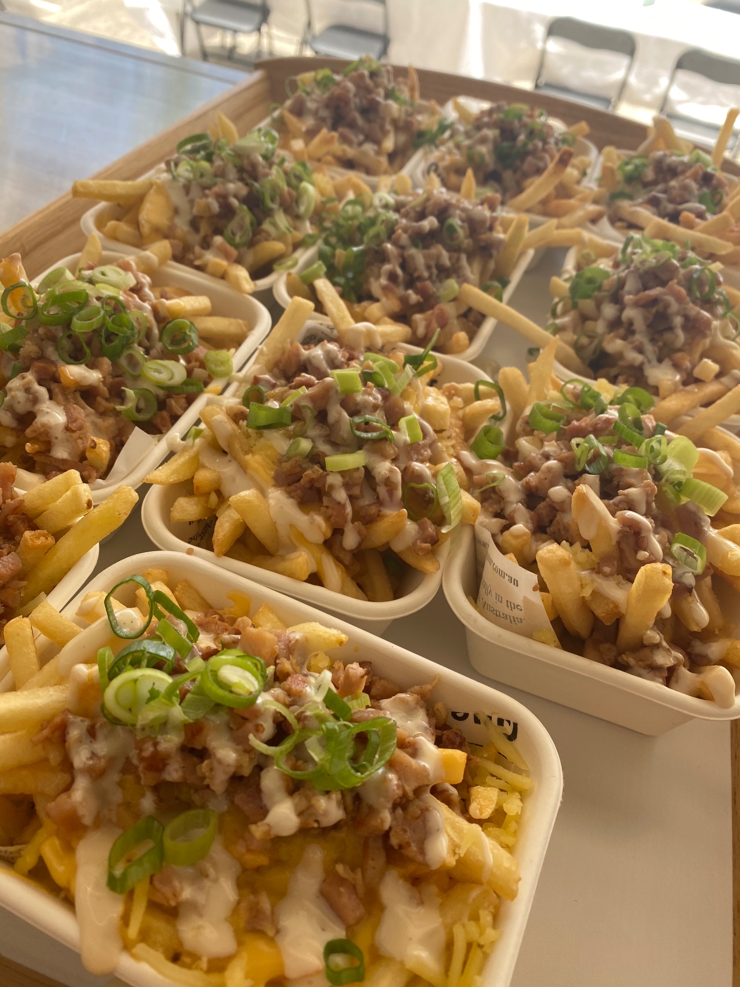Loaded fries with cheese sauce and spring onion served in catering cups